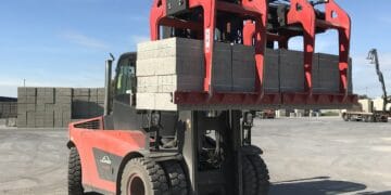 A red forklift with a load of bricks on it, used by Big 5 Construct Saudi and equipped with B&B Attachments.