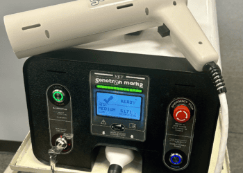 A veterinary pain treatment machine, specifically the ADMT or Vet-Sonotron, placed on a table.