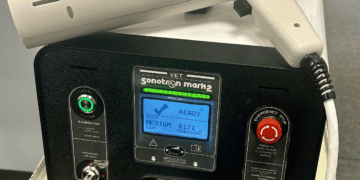 A veterinary pain treatment machine, specifically the ADMT or Vet-Sonotron, placed on a table.