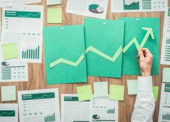 Green upward trend graph on papers with financial data. MONEYVAL reports. - Supply Chain News
