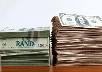 Stacks of US dollar bills and South African Rand banknotes. Trade uncertainty. - Supply Chain News