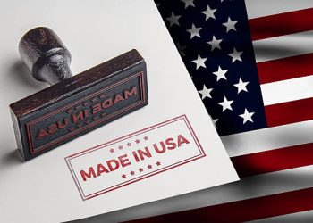 Made in USA stamp on paper next to American flag - Supply Chain News