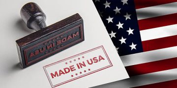 Made in USA stamp on paper next to American flag - Supply Chain News