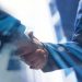 Businesspeople shaking hands, symbolizing a trade agreement or negotiation impacted by increased tariffs. - Supply Chain News