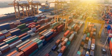 Aerial view of a busy container port, illustrating global trade and the impact of US tariff policy shifts. - Supply Chain News