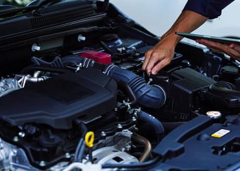 Mechanic inspecting car engine with digital tablet - Supply Chain News