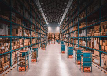 Warehouse interior with rows of boxes and autonomous robots, potentially impacted by US tariffs on imported goods. - Supply Chain News